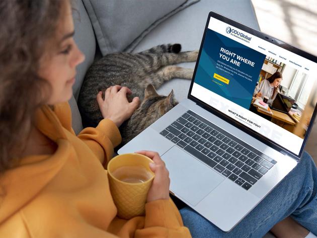 Woman with cat on laptop looking at odu global website